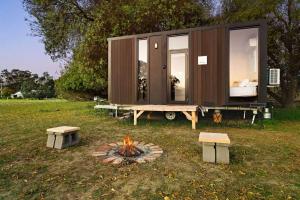 a tiny house with a fire pit in a field at Pyrenees Views by Tiny Away in Avoca