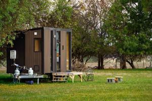 a tiny house sitting in the grass in a field at Pyrenees Views by Tiny Away in Avoca
