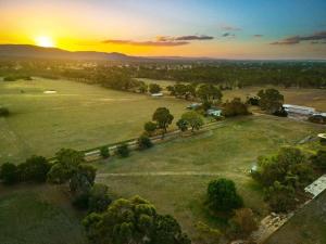 an aerial view of a field with the sunset in the background at Pyrenees Views by Tiny Away in Avoca