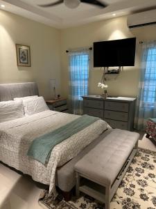 a bedroom with a bed and a flat screen tv at Villa Christine in Ocho Rios