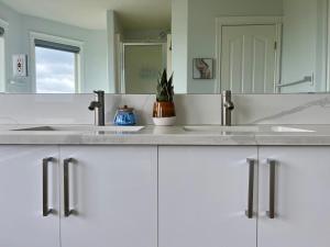 ein Badezimmer mit zwei Waschbecken und einem Spiegel in der Unterkunft Acreage, 5 bdrm, King Bed, AC, Wood Fireplace, Rural in Balzac + 34 Fotos