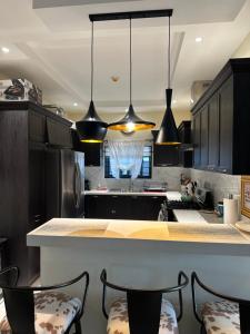 a kitchen with black cabinets and a counter with chairs at Villa Christine in Ocho Rios