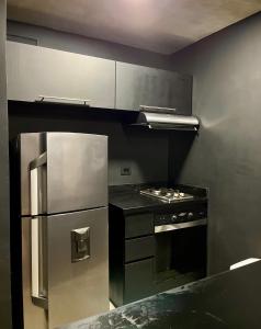a kitchen with a stainless steel refrigerator and a stove at Executive Suite - Llanogrande in San Antonio de Pereira