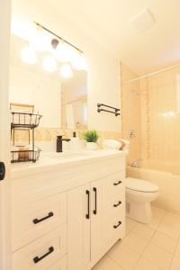 ein Badezimmer mit Waschbecken, Toilette und Spiegel in der Unterkunft Rocky Mtn Escape-3 bdrm-near shops, dining, UofC in Calgary