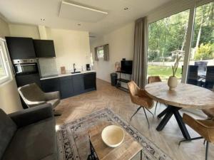 a living room with a table and a kitchen at Chalet in Hengelo near Twickel Castle in Haaksbergen