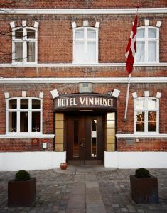 a building with a hotel valkyrie sign and a flag at Hotel Vinhuset in Næstved