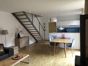 a living room and kitchen with a table and a staircase at At the Church Stairs - Holiday Home II in Blankenburg