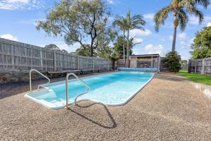 a swimming pool in a yard with a fence at Serenity in Lakes Entrance