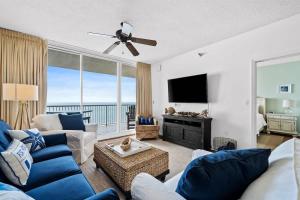 a living room with a blue couch and a tv at Pool & Spa - Beachfront - Golf - King Bed in Gulf Highlands