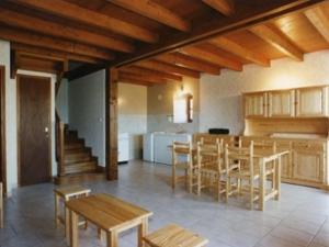 a kitchen and dining room with wooden tables and chairs at Maison confortable avec terrasse, près de Belvès - jardin clos, BBQ, animaux acceptés - FR-1-616-20 in Bouillac
