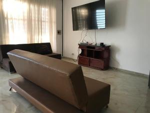 a living room with a couch and a flat screen tv at Villa Campestre SAN JOSÉ in Guamo