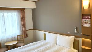 Postel nebo postele na pokoji v ubytování Toyoko Inn Moriya Ekimae