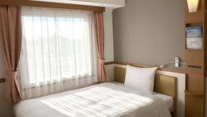 Postel nebo postele na pokoji v ubytování Toyoko Inn Moriya Ekimae