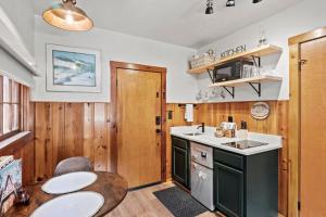 a kitchen with wooden walls and a table and a sink at Timber Lodge #7 in Colorado Springs