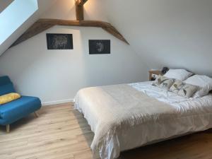 a bedroom with a bed and a blue chair at Gîte spacieux et confortable proche de La Flèche - FR-1-410-471 in Villaines-sous-Malicorne