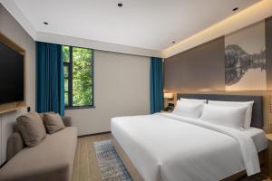 九江Tianhai Botang Hotel, Guling Street, Lushan Scenic Area的卧室里有一张白色的大床和一张沙发 更多25张照片