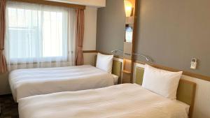 Postel nebo postele na pokoji v ubytování Toyoko Inn Moriya Ekimae
