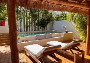 a patio with a couch and chairs on a wooden deck at Casa alado de la playa in Cancún