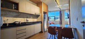 a kitchen with a counter and a table and chairs at City Zen Apartments in Sao Jose do Rio Preto