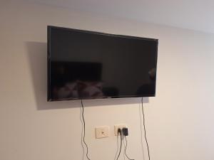 a flat screen tv hanging on a wall at Hermoso y céntrico in Cochabamba