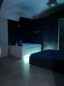 een donkere kamer met een wastafel en een bed bij HomeSuite45 in Catania