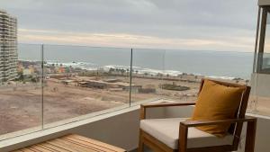 a chair sitting in front of a large window at Hermoso departamento de 1D, terraza y vista al mar in Antofagasta +4 photos