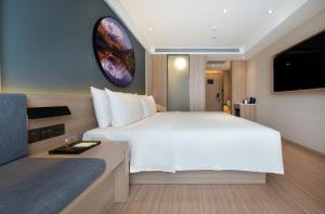 a bedroom with a large white bed and a tv at Atour Light Hotel (Chengdu Hi-tech West Zone University of Electronic Technology) in Chengdu +20 photos