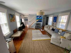 ein Wohnzimmer mit Sofa und Tisch in der Unterkunft Historic Renovated Sun-drenched Ptown House in Provincetown