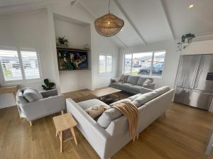 a living room with a couch and two chairs at Palm Retreat - Whitianga in Whitianga