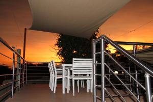 un tavolo e sedie su un balcone al tramonto di 46 Welgevonden in Dinokeng a Dinokeng Game Reserve