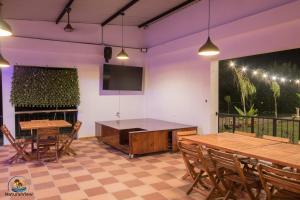 a room with tables and chairs and a flat screen tv at Natural View Resorts Melgar in Melgar