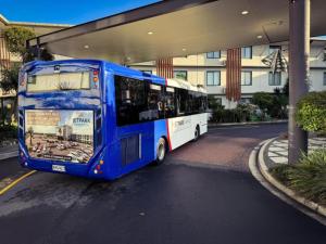 a blue bus parked in front of a building at JetPark Auckland Airport Hotel in Auckland