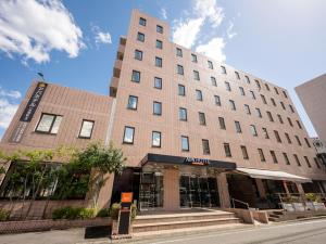 un edificio en una calle frente a un edificio en APA Hotel Maebashieki-Kita, en Maebashi