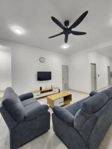 a living room with two couches and a ceiling fan at 31 RIMBUN KIARA KEPAYANG SEREMBAn in Seremban
