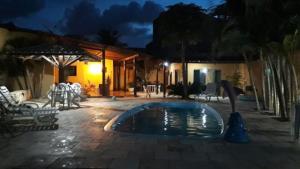 a swimming pool in the middle of a patio at night at Cantinho da paz in Maragogi +16 photos