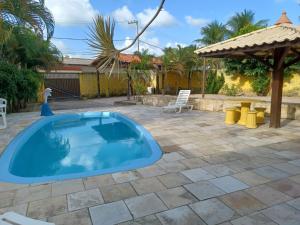 a swimming pool in a patio with a gazebo at Cantinho da paz in Maragogi