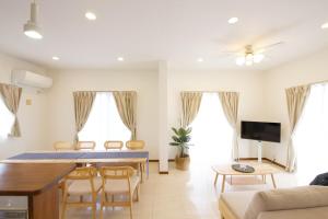 a living room with a table and a couch at Maeda Vacation Style in Onna