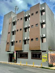 a large building with cars on the side of it at Hotel pousada estação dos devotos in Aparecida