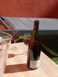 Una botella de vino sobre una mesa con dos copas. en Very quiet 2-person studio with a hot tub, en Villeurbanne 4 fotos más