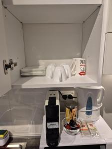 a kitchen with a coffee maker on a shelf at AV Urban Retreat in Ploieşti
