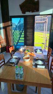 a wooden table with plates and glasses on top of it at New Highland Hotel Yen Bai in Kim Nội