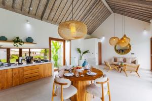 a kitchen and living room with a wooden table and chairs at Villa Maria-2BR Private Villa in Canggu in Kerobokan