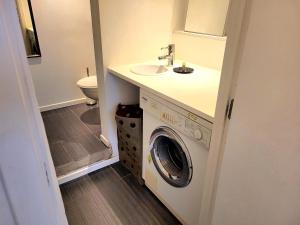a bathroom with a washing machine and a sink at Cosy flat, central location in Brussels