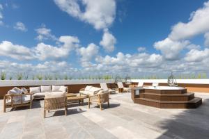 a patio with chairs and tables on a roof at Hotel Mundo Maya Tulum Aeropuerto in Tulum