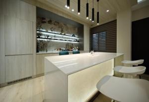 a large kitchen with a white counter and stools at 芙若蕥居 in Qingshui