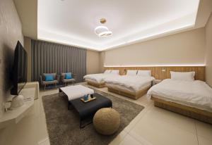a hotel room with two beds and a tv at 芙若蕥居 in Qingshui