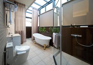 a bathroom with a tub and a toilet and a shower at 芙若蕥居 in Qingshui