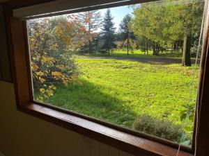 une fenêtre avec vue sur un champ d'herbe dans l'établissement Cabañita Uriflor, à Los Ángeles