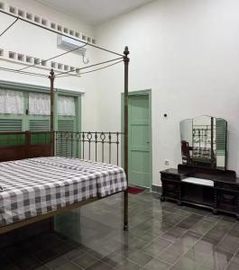 a bedroom with a bed and a dresser and a mirror at vintage room 1 in colonial house in Kamparganya