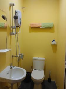 La salle de bains est pourvue de toilettes blanches et d'un lavabo. dans l'établissement Moon Eleven Hostel Near Klia & Klia2, à Sepang